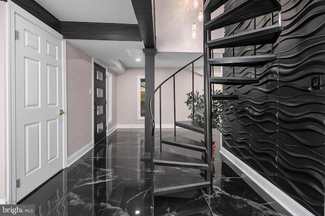 stairway featuring decorative columns, marble finish floor, and baseboards