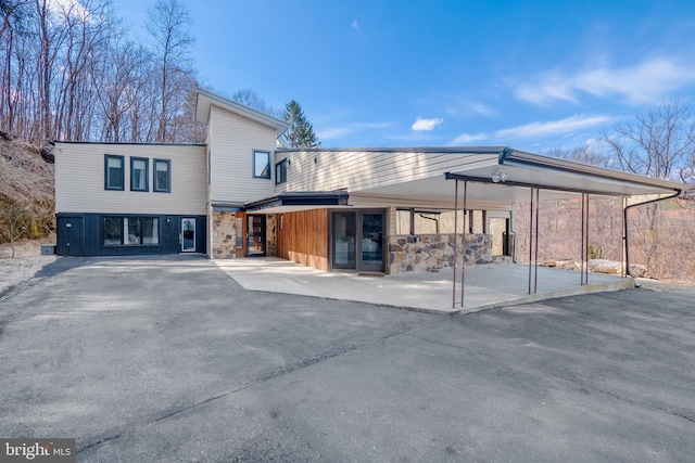 exterior space with an attached carport and stone siding