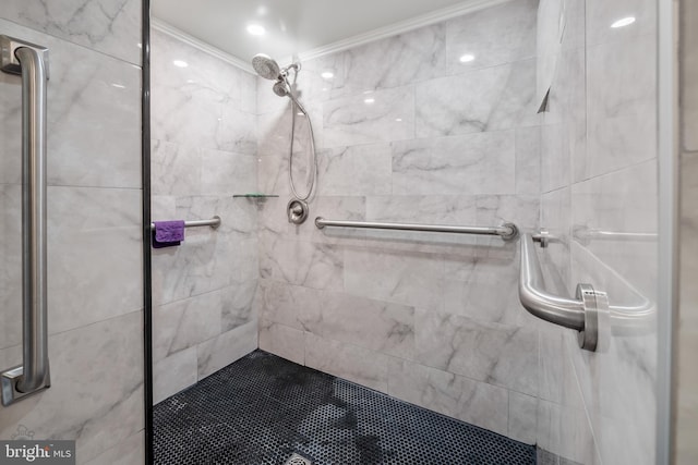 bathroom with ornamental molding and a tile shower