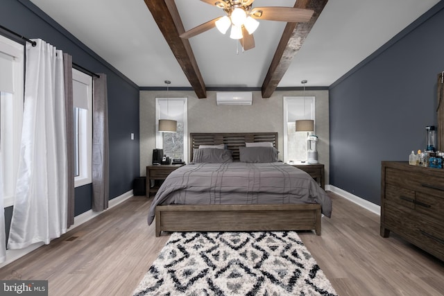 bedroom featuring beam ceiling, light wood-style flooring, baseboards, an AC wall unit, and ornamental molding
