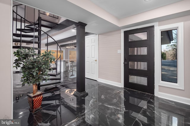 foyer with baseboards, marble finish floor, and stairs