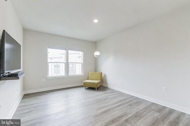 living area featuring baseboards and wood finished floors