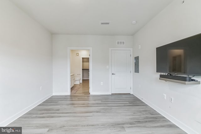 unfurnished bedroom with baseboards, visible vents, electric panel, and light wood finished floors