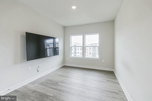 empty room with baseboards and light wood-style floors