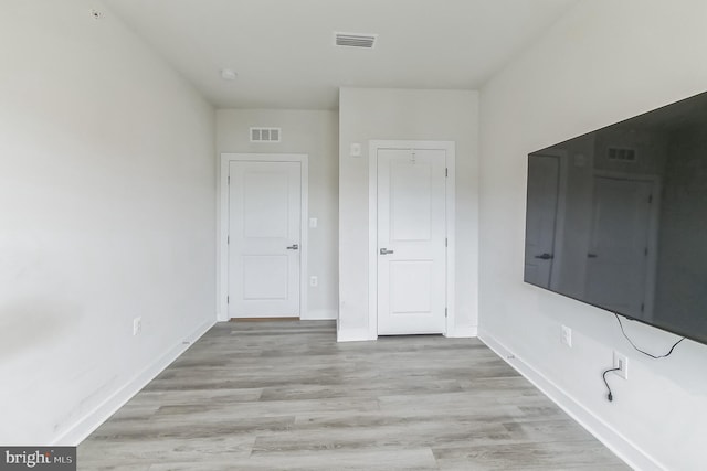 spare room with baseboards, visible vents, and light wood-style flooring