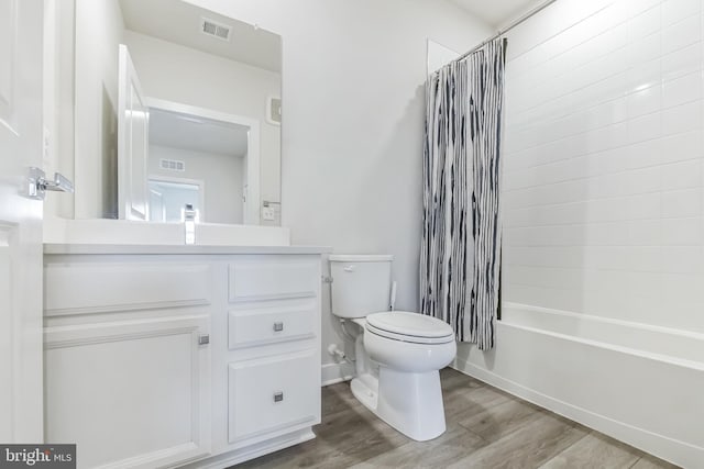 full bath featuring toilet, vanity, wood finished floors, and visible vents