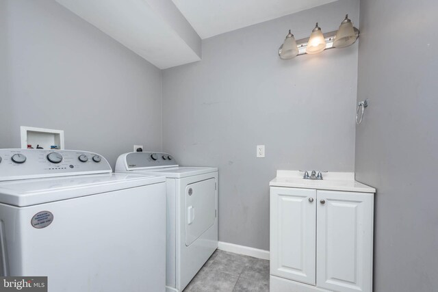 2110 E Hoffman St, Baltimore, MD 21213 - washroom with washer and clothes dryer, a sink, light tile patterned floors, baseboards, and cabinet space