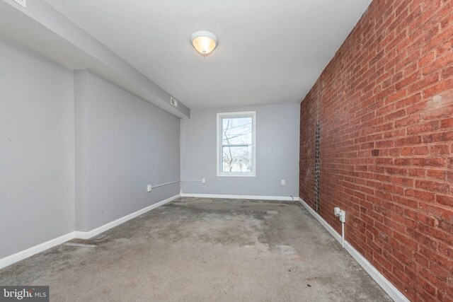 2110 E Hoffman St, Baltimore, MD 21213 - unfurnished room featuring baseboards and brick wall