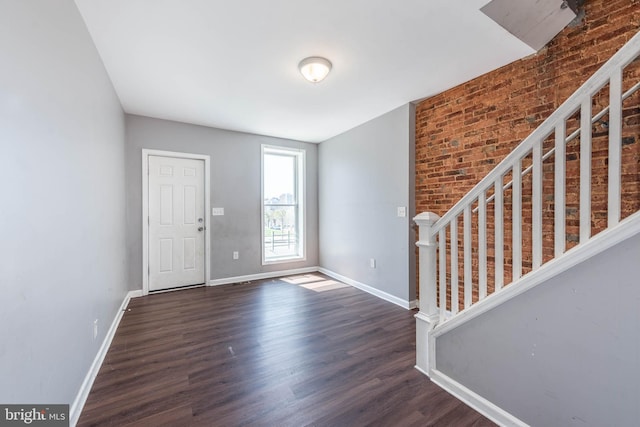2110 E Hoffman St, Baltimore, MD 21213 - entryway with baseboards, brick wall, stairway, and dark wood finished floors