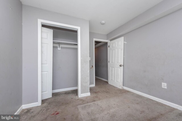 2110 E Hoffman St, Baltimore, MD 21213 - unfurnished bedroom featuring baseboards, a closet, and carpet