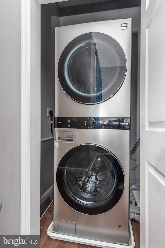 2118 E Hoffman St, Baltimore, MD 21213 - clothes washing area featuring wood finished floors, stacked washer and clothes dryer, and laundry area