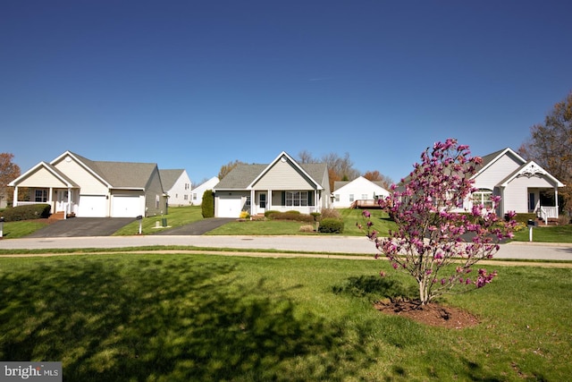view of front facade featuring a residential view, an attached garage, a front lawn, and aphalt driveway