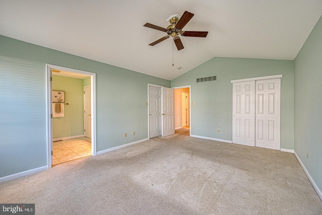 unfurnished bedroom featuring vaulted ceiling, visible vents, and baseboards