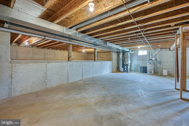 basement featuring water heater and heating unit