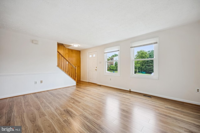 25510 Coltrane Dr, Damascus, MD 20872 - unfurnished living room with stairway, wood finished floors, and a textured ceiling