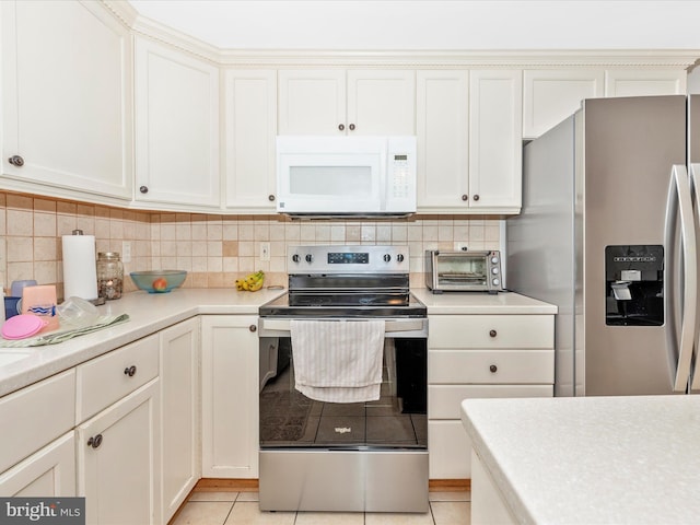kitchen featuring tasteful backsplash, light tile patterned floors, light countertops, stainless steel appliances, and a toaster