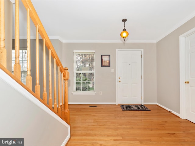 entryway featuring stairs, light wood finished floors, baseboards, and crown molding