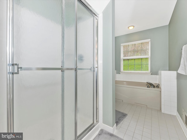 bathroom featuring tile patterned floors, a shower stall, baseboards, and a garden tub