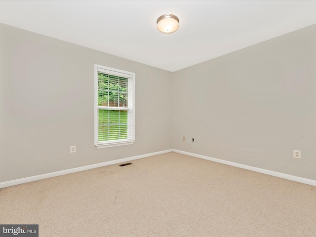 carpeted empty room featuring baseboards and visible vents