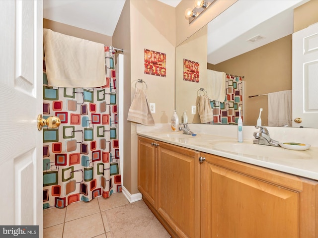 bathroom with tile patterned flooring, double vanity, visible vents, and a sink