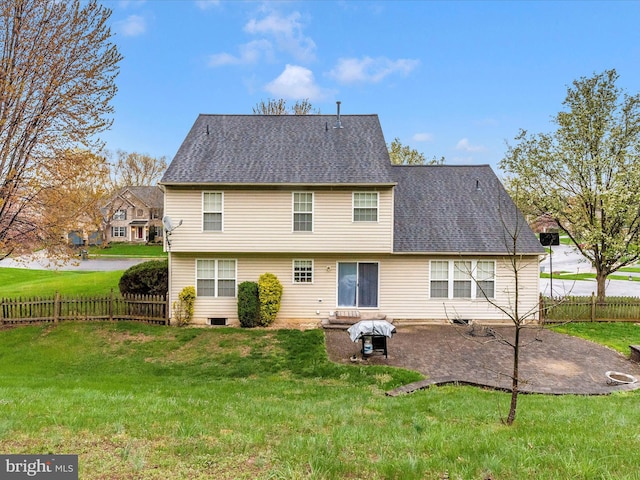 rear view of property featuring a patio, a shingled roof, fence, and a lawn