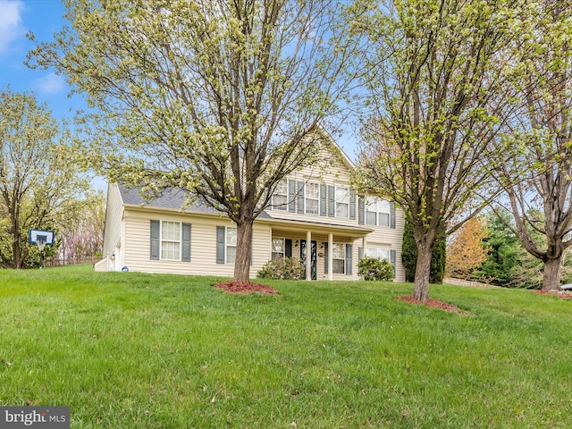 traditional-style house featuring an attached garage and a front yard