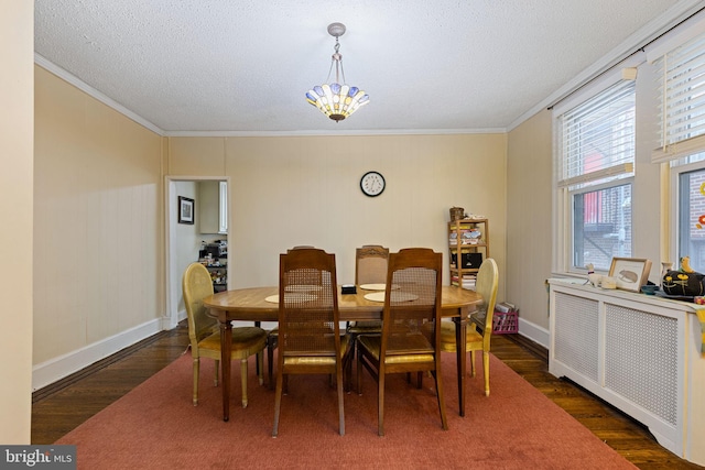 dining area featuring baseboards, wood finished floors, a textured ceiling, and crown molding