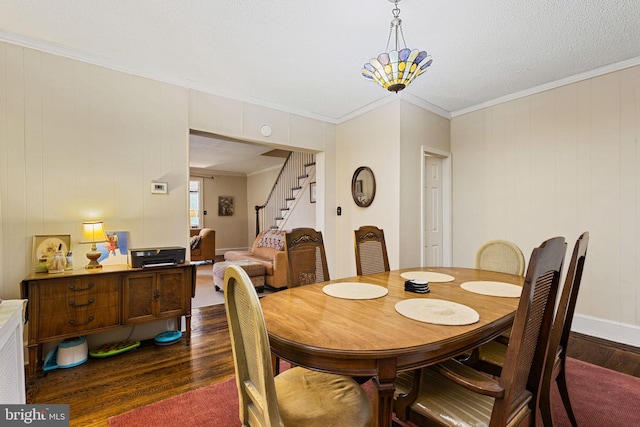 dining room with dark wood finished floors, crown molding, and stairs