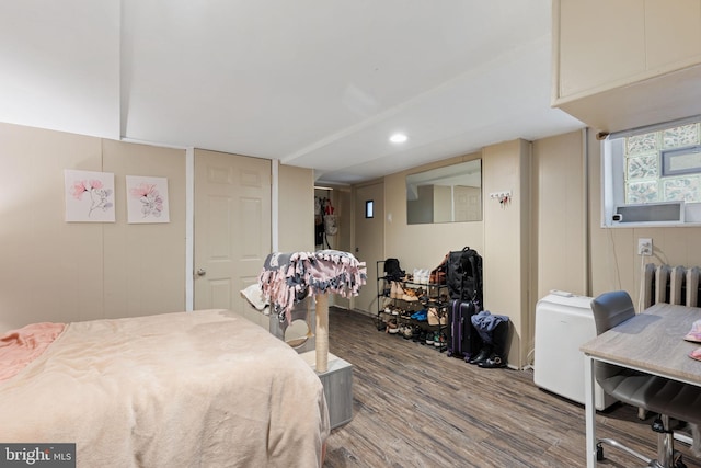 bedroom with radiator and wood finished floors