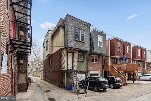 view of front of home featuring a residential view, a shingled roof, stairs, and mansard roof