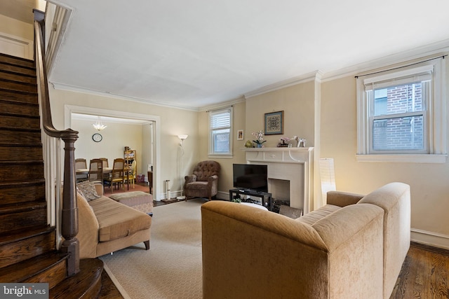 living room with stairway, dark wood-style floors, ornamental molding, baseboards, and a fireplace
