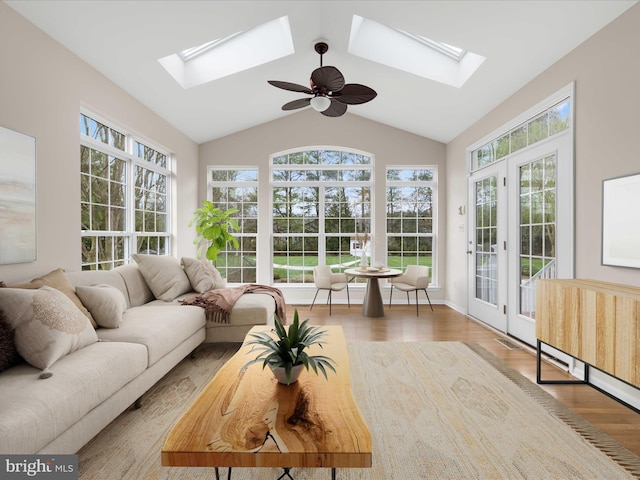 sunroom / solarium featuring french doors, lofted ceiling with skylight, a wealth of natural light, and wood finished floors