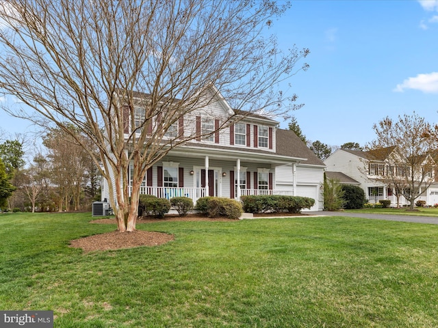 colonial house with central air condition unit, a garage, a front lawn, driveway, and covered porch