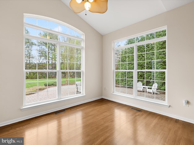 empty room featuring visible vents, wood finished floors, ceiling fan, and vaulted ceiling