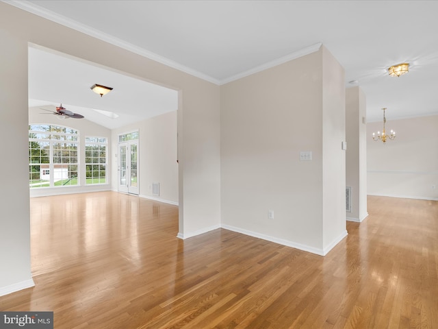 unfurnished room with ornamental molding, ceiling fan with notable chandelier, light wood-style floors, and baseboards