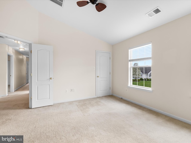 unfurnished bedroom featuring carpet floors, baseboards, lofted ceiling, and visible vents