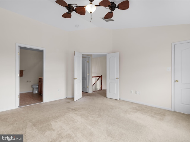 unfurnished bedroom featuring light carpet, baseboards, ensuite bathroom, and visible vents