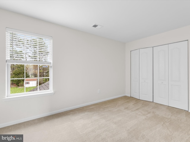 unfurnished bedroom with baseboards, carpet floors, and multiple windows