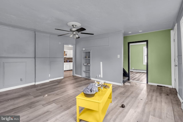 423 Main St, Dorchester, NJ 08316 - unfurnished living room featuring ornamental molding, baseboard heating, ceiling fan, and wood finished floors