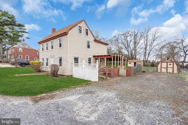 423 Main St, Dorchester, NJ 08316 - view of property exterior with an outdoor structure, fence, a storage unit, a yard, and a chimney