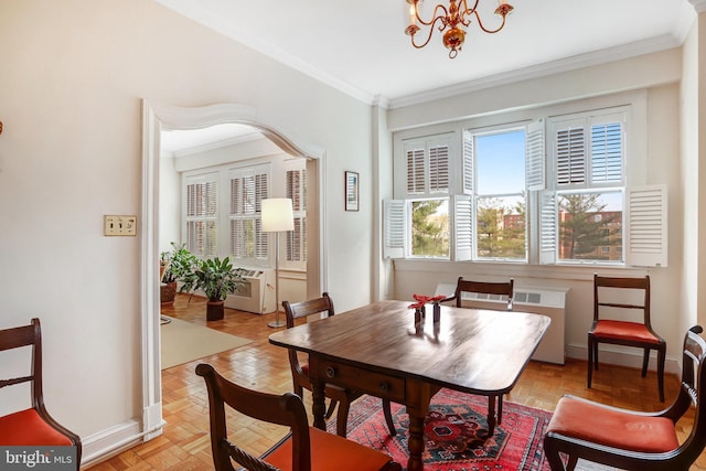 dining space featuring crown molding, baseboards, and a chandelier