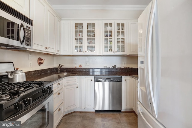 kitchen with a sink, white cabinetry, ornamental molding, and stainless steel appliances