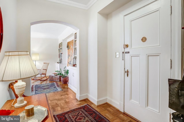 foyer with arched walkways, ornamental molding, and baseboards