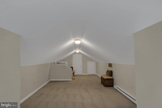 additional living space with lofted ceiling, baseboard heating, baseboards, and carpet