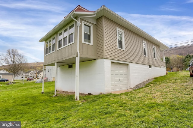 view of side of property featuring a lawn and a garage