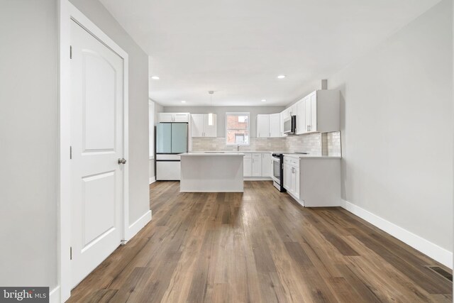kitchen featuring refrigerator, baseboards, backsplash, white cabinets, and range with electric cooktop