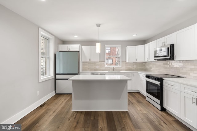kitchen featuring baseboards, stainless steel microwave, refrigerator, dark wood-type flooring, and range with electric cooktop