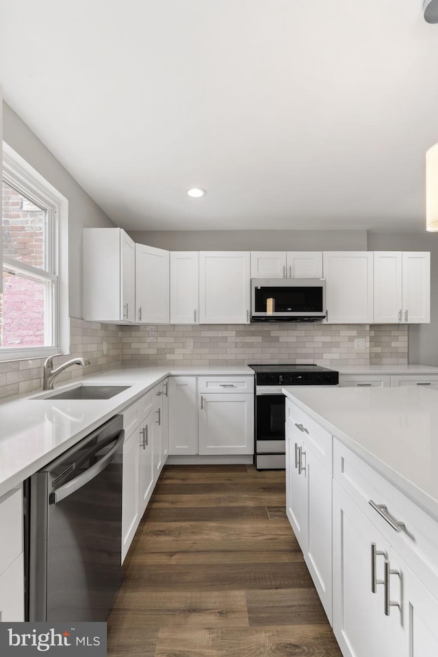 kitchen featuring a sink, white cabinets, electric range oven, and stainless steel dishwasher