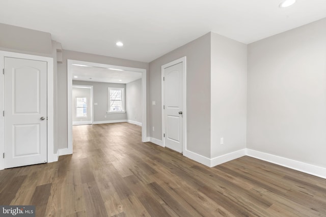 unfurnished room with baseboards, wood finished floors, and recessed lighting