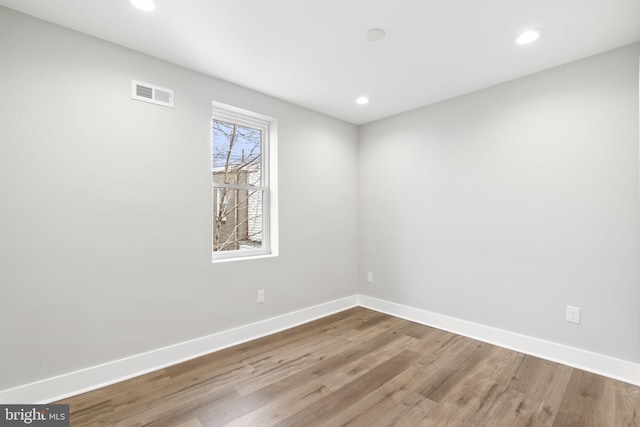 spare room featuring baseboards, visible vents, recessed lighting, and wood finished floors